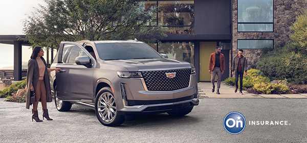 A woman is standing at the passenger door of a Cadillac Escalade while two men walk out of a very modern stone home in the background. OnStar Insurance logo is in the bottom right hand corner of the image